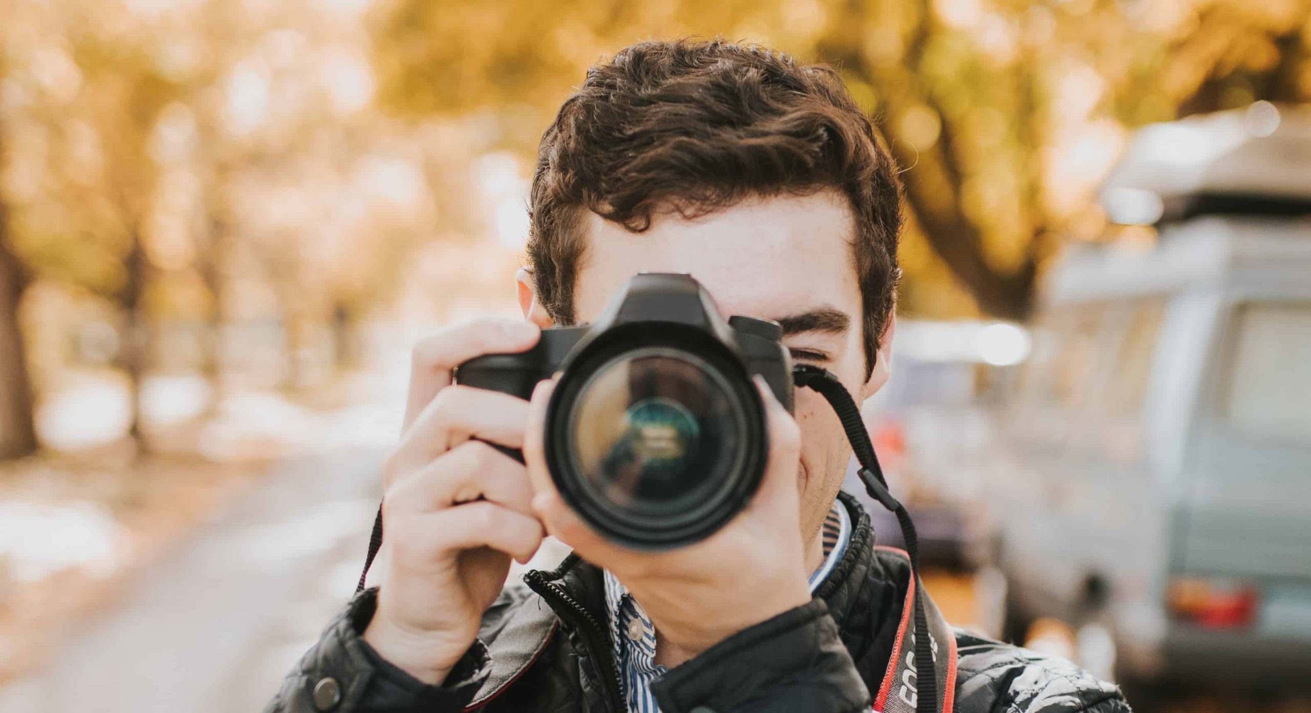 Beginner photographer holding a camera, from Great Big Photography World's free course